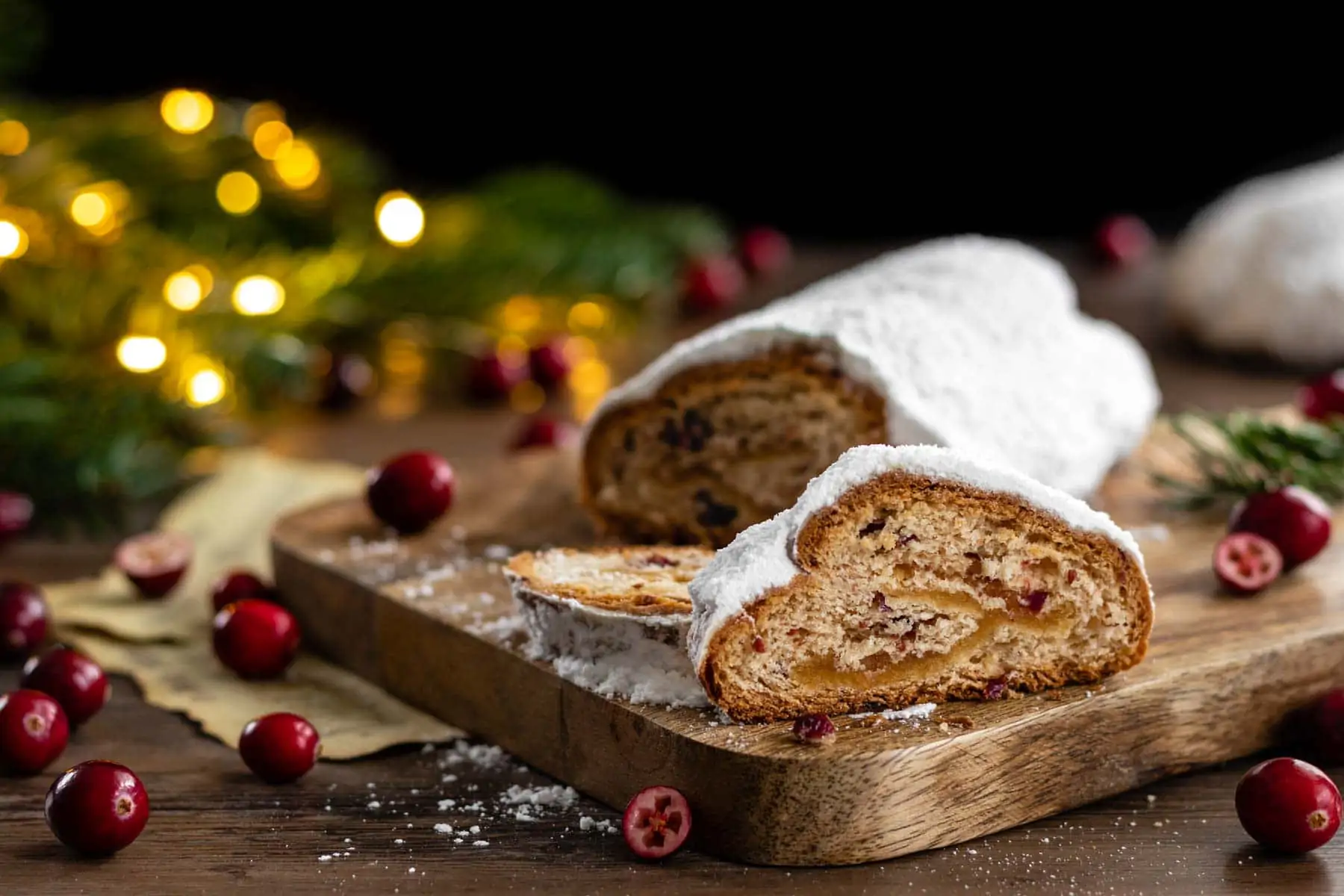 Cranberry-Marzipan-Stollen ohne Rosinen, Orangeat und Zitronat angeschnitten auf einem Holzbrett.