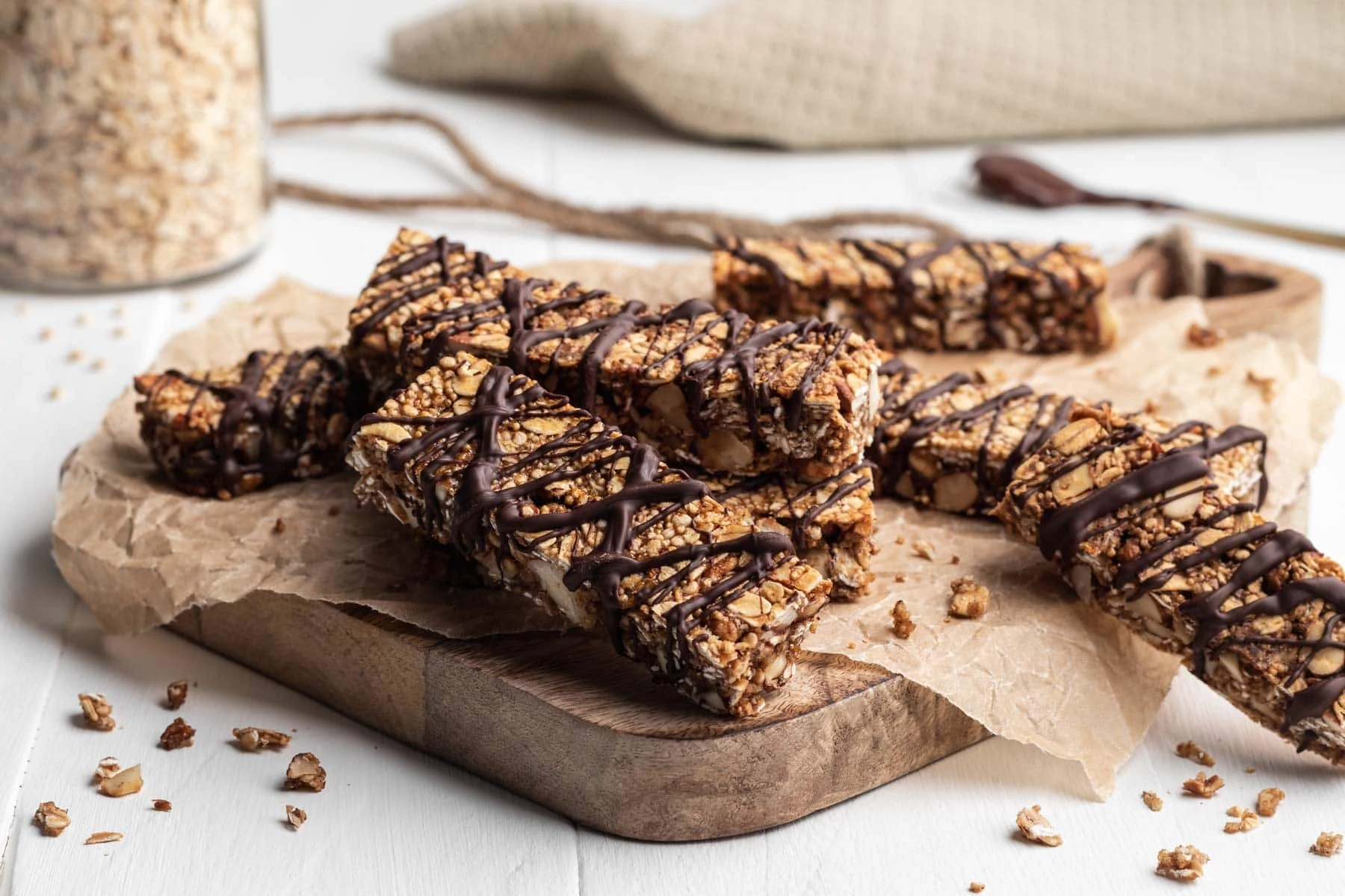 Vegane Schoko-Bananen Müsliriegel ohne raffinierten Zucker verziert mit Schokolade auf einem Backpapier.