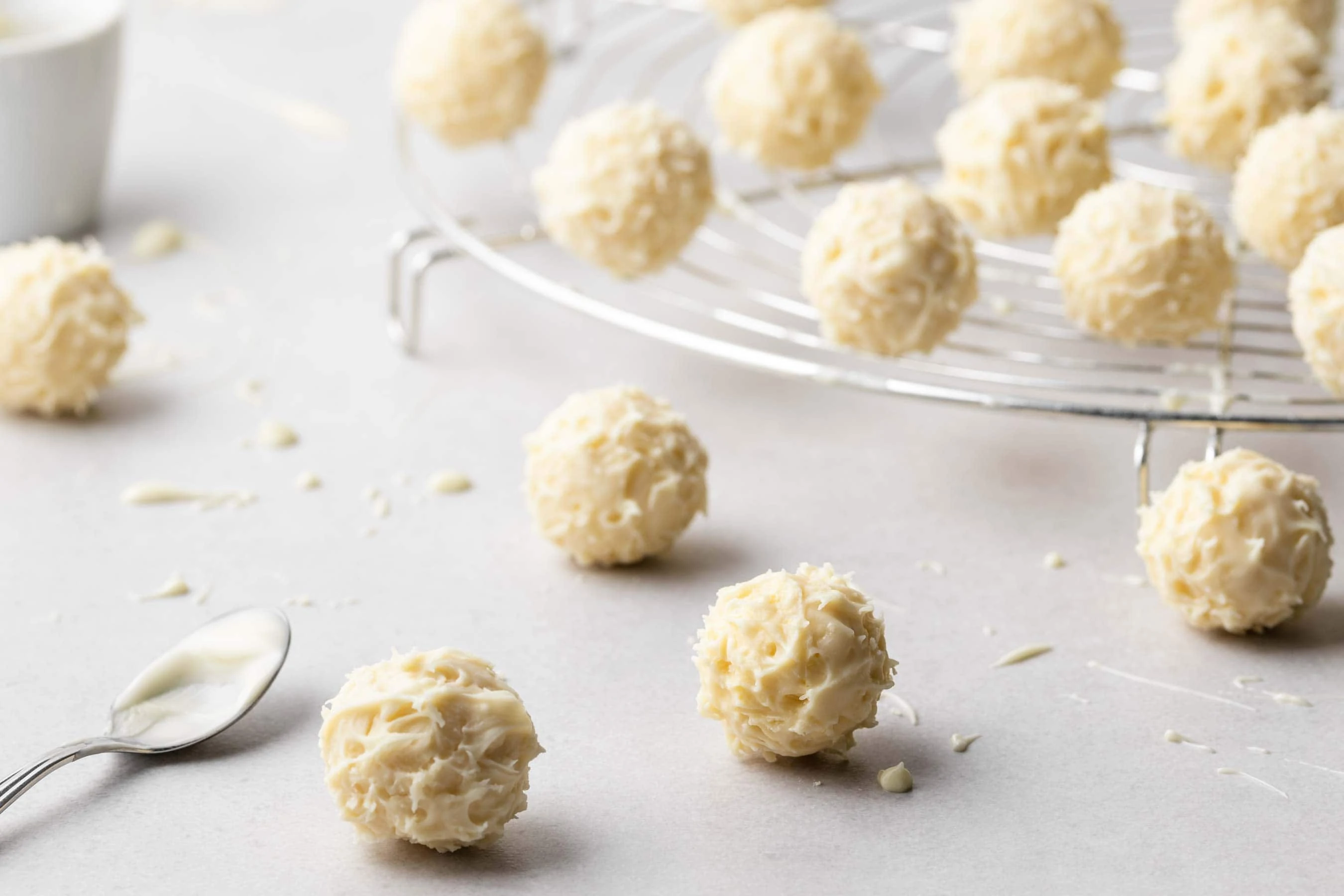 Eierlikör-Pralinen mit weißer Schokolade überzogen auf einem Abkühlgitter.