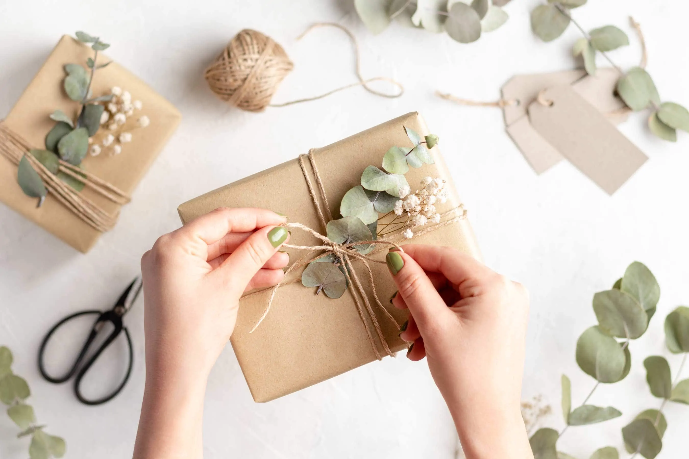 Es wird gerade die Schleife für ein nachhaltig verpacktes Geschenk für die Küche festgezogen.