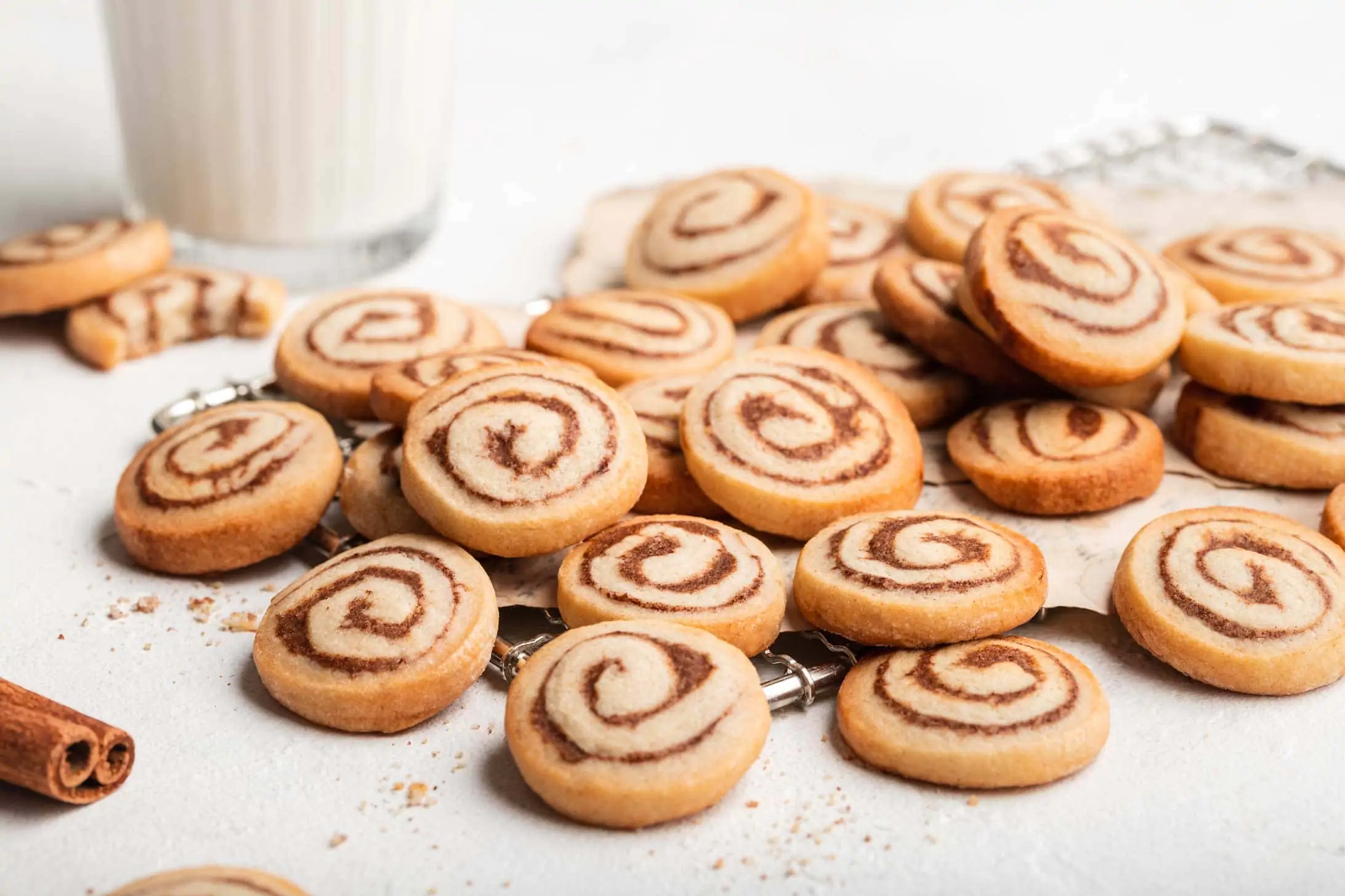 Zimtschnecken Plätzchen aus Mürbeteig mit einer Zimt-Nuss-Füllung liegen auf einem Gitter.