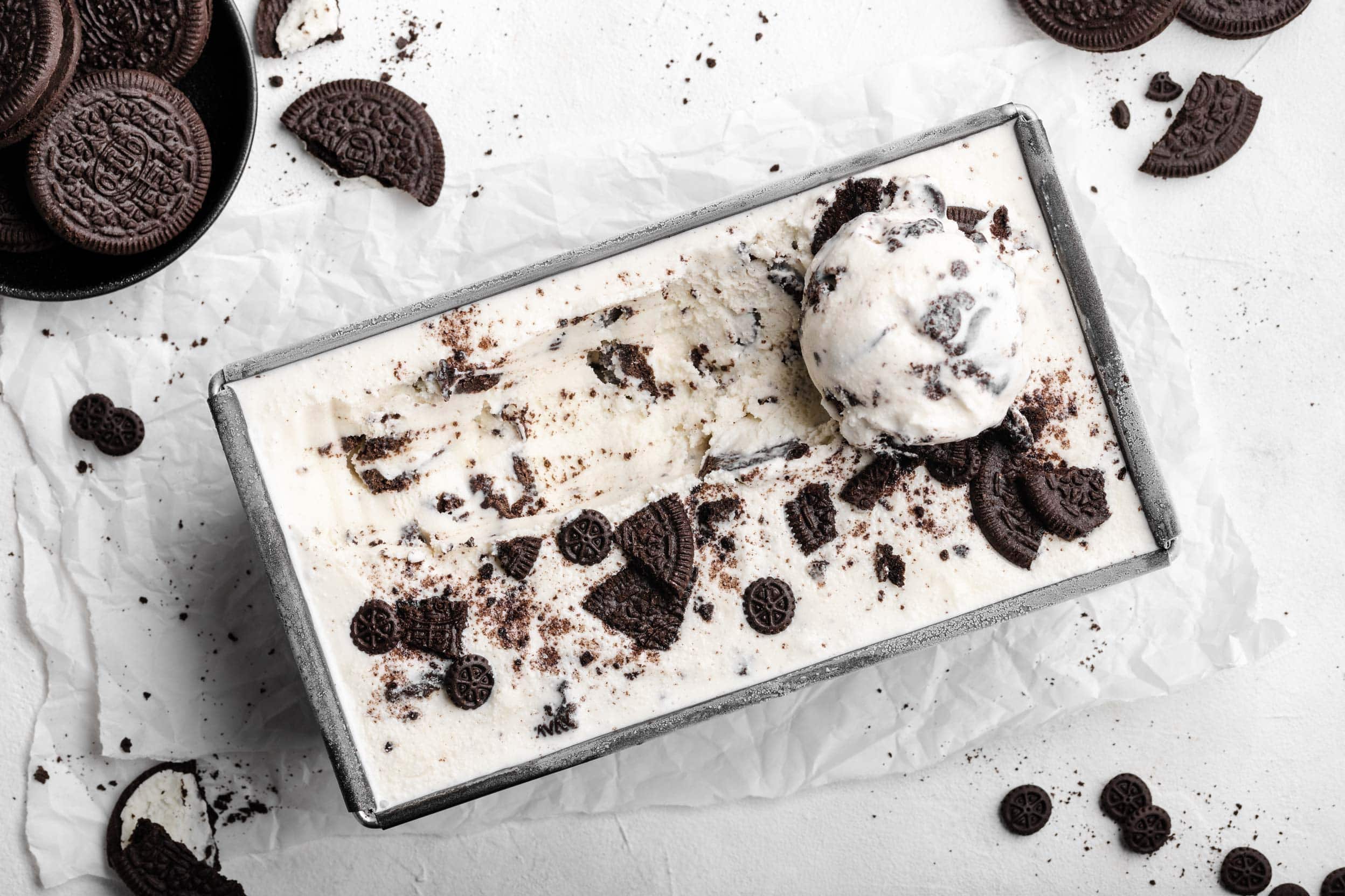 Das fertige, selbstgemachte Oreo-Eis in einer Form. Auf dem Eis liegen zerbröselte Kekse und eine Kugel Oreo-Eis.