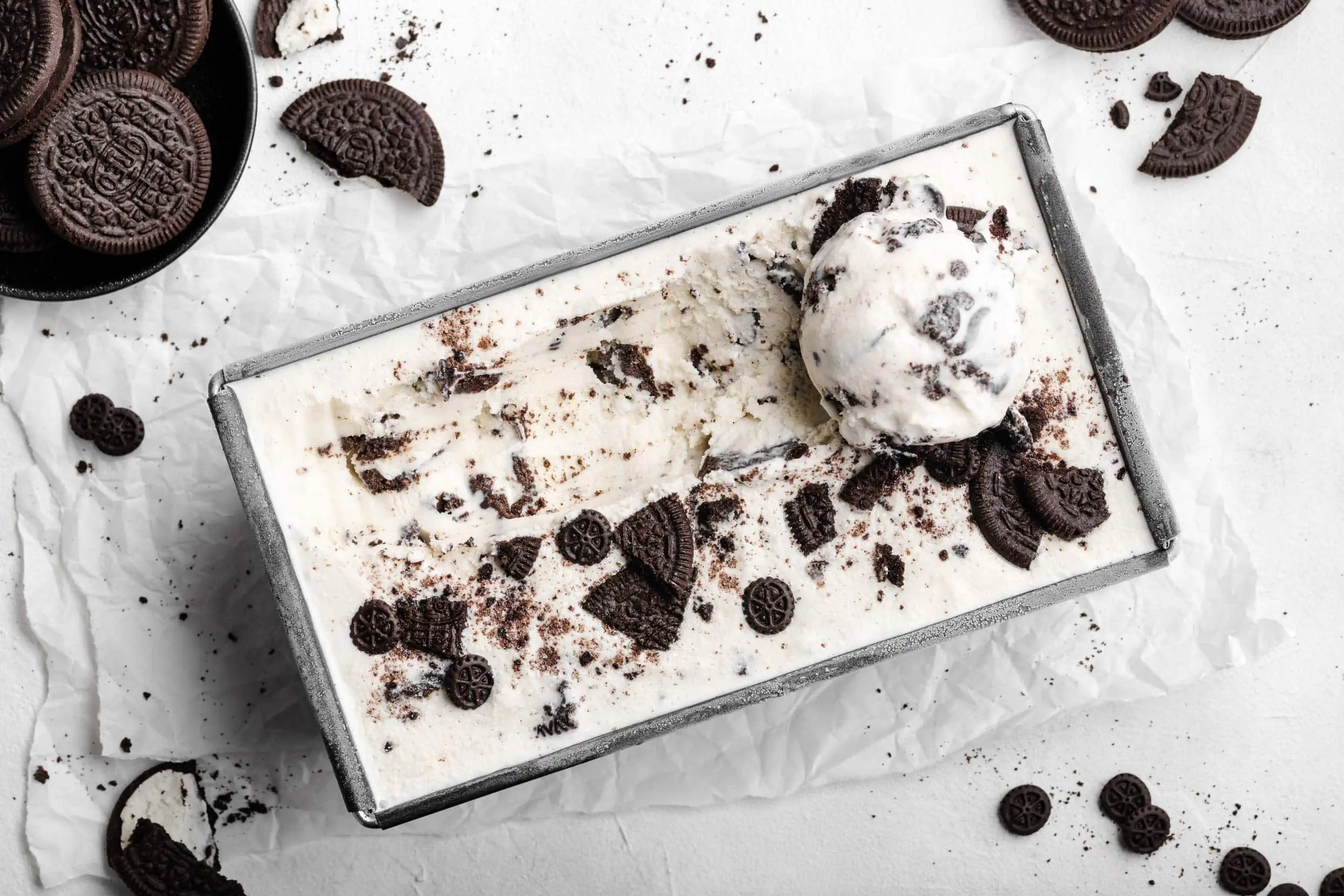 Das fertige, selbstgemachte Oreo-Eis in einer Form. Auf dem Eis liegen zerbröselte Kekse und eine Kugel Oreo-Eis.