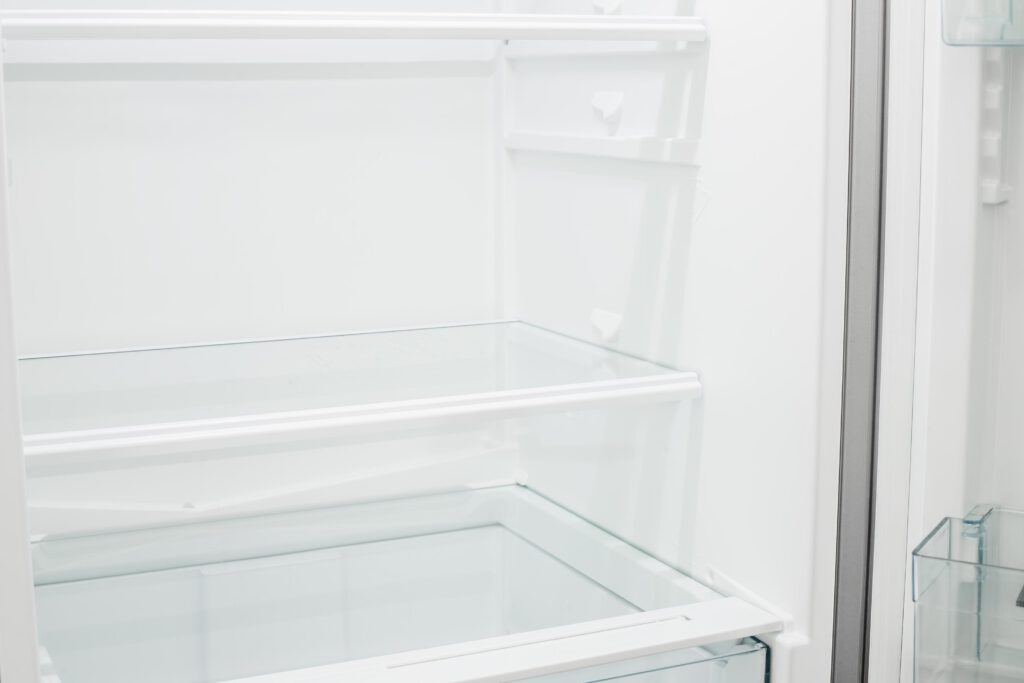 Ein sauberer Kühlschrank der gerade gereinigt wurde und nun neu eingeräumt und organisiert wird.