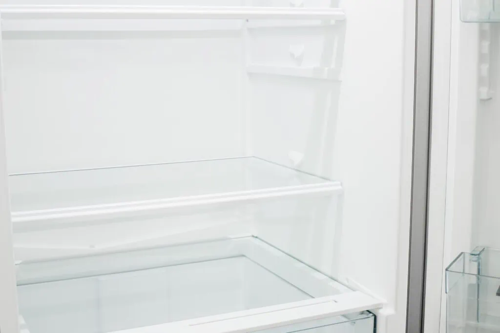 Ein sauberer Kühlschrank der gerade gereinigt wurde und nun neu eingeräumt und organisiert wird.