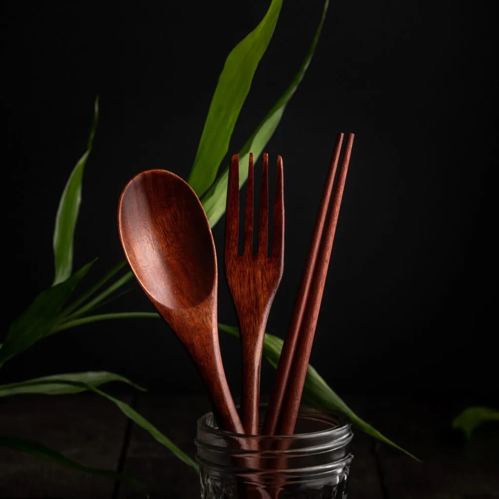 Ein asiatisches Besteck-Set aus Holz, bestehend aus einem Holzlöffel, einer Gabel und Essstäbchen.