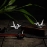 Mehrere Hashioki Essstäbchenhalter in Form von Origami-Kranichen aus Keramik.