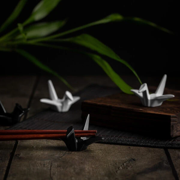 Mehrere Hashioki Essstäbchenhalter in Form von Origami-Kranichen aus Keramik.