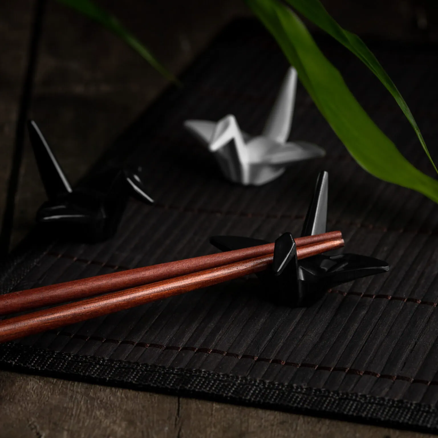 Japanische Essstäbchenhalter in schwarz und weiß in der Form von Origami-Kranichen.