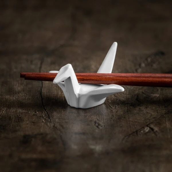 Ein weißer Hashioki Essstäbchenhalter in der Form des kulturellen Origami-Kranich.
