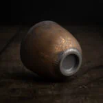 Eine liegende Teetasse aus hochwertiger Keramik im japanischen Stil mit einem goldenen Metallüberzug.