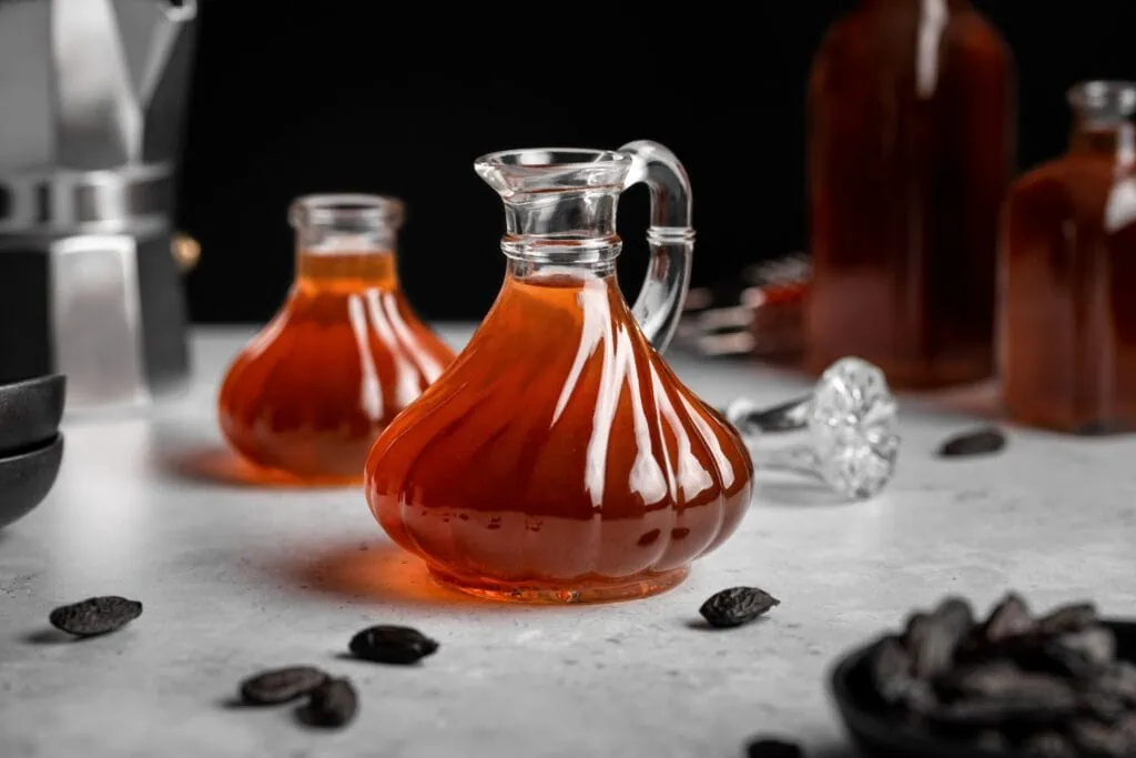 Selbstgemachter Tonkabohnensirup abgefüllt in unterschiedlichen Flaschen.