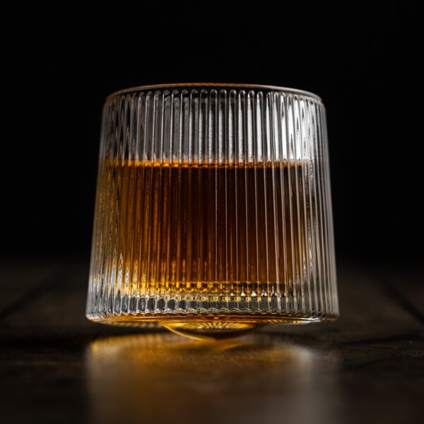Ein ausgefallenes Whiskyglas mit rundem Boden und feinem Zierschliff gefüllt mit Whisky.