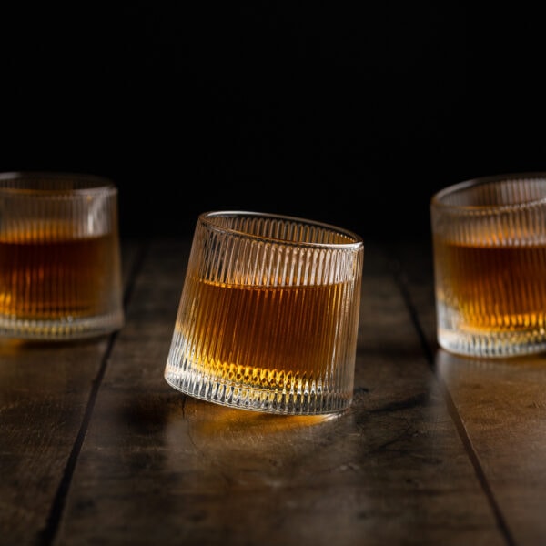 Drei originelle Wackelgläser mit rundem Boden gefüllt mit einem Whisky.