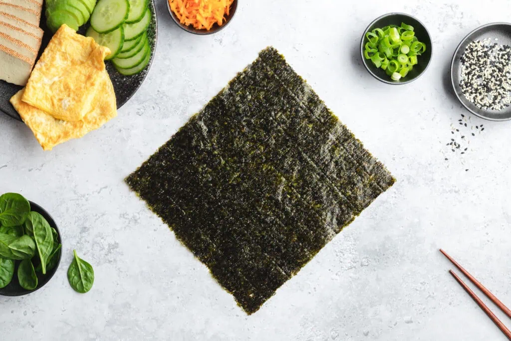 Ein Nori-Blatt auf einer Arbeitsfläche für den ersten Zubereitungsschritt der Onigirazu.