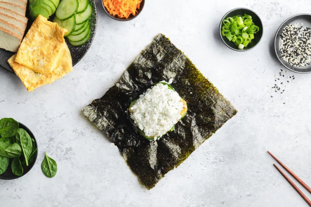 Im vierten Schritt wird das Sushi Sandwich mit einer weiteren Schicht Reis belegt.