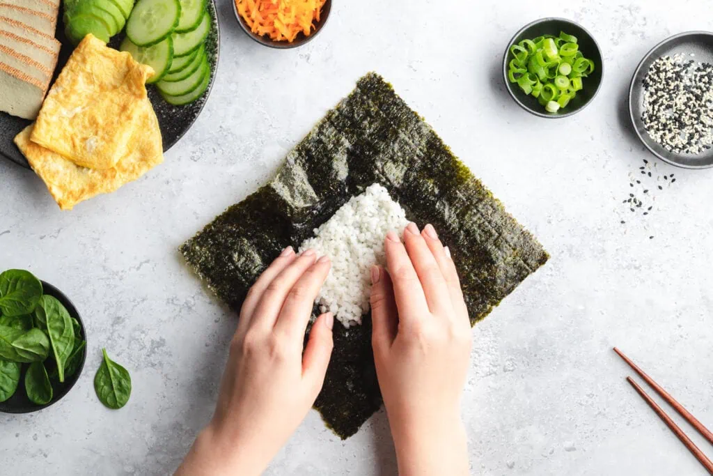 Das Sushi-Sandwich wird im zweiten Schritt der Zubereitung mit Reis gefüllt.