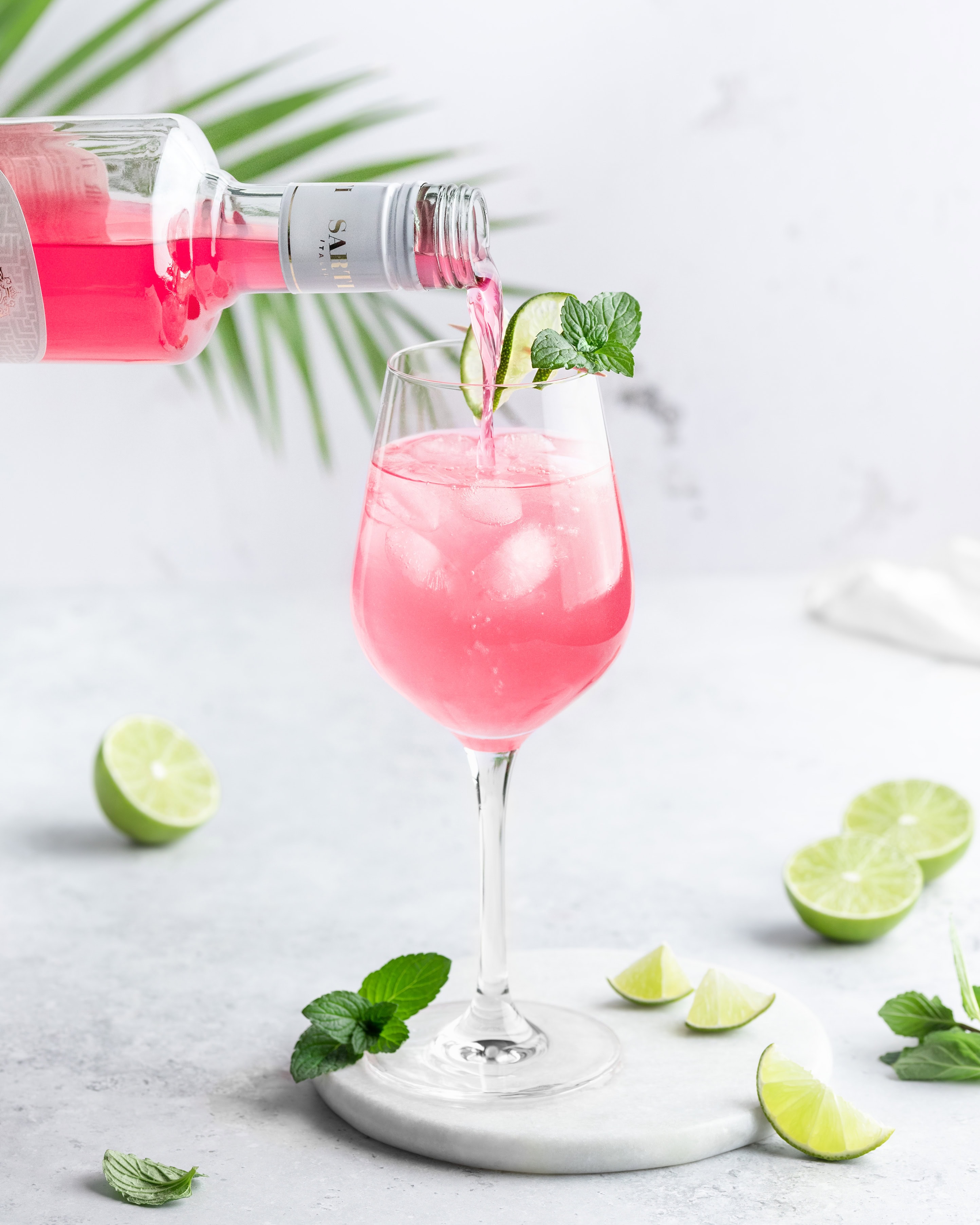 Ein Sarti Spritz wird gerade mit dem rosafarbenen Likör Sarti Rosa zubereitet.