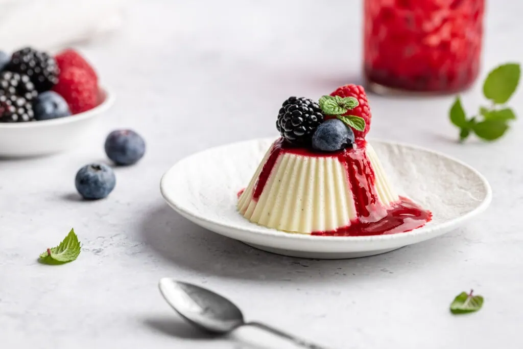 Eine mit Beeren garnierte vegetarische Panna Cotta ohne Gelatine mit Agar Agar.