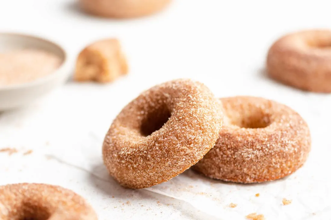 Saftige Apfel-Donuts frisch aus dem Backofen wurden gerade mit Zimt und Zucker überzogen.