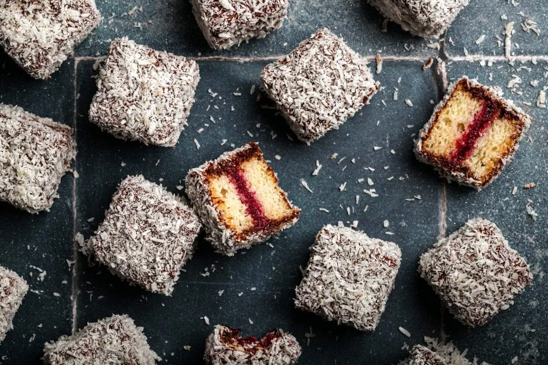 Saftiger Kuchen mit Kokosflocken in Würfeln mit einer fruchtigen Marmeladenfüllung, die in Australien als Lemingtons bezeichnet werden.