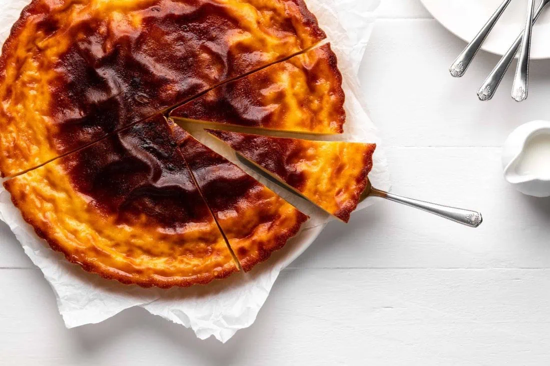 Galatopita, ein griechischer Kuchen mit Grieß, angeschnitten auf einer Kuchenplatte.