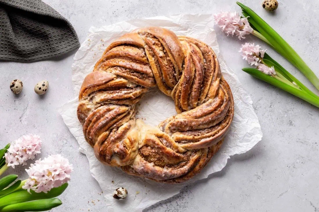 Ein runder Hefekranz mit einer Marzipanfüllung mit Nüssen und einer Glasur aus Zuckerguss.