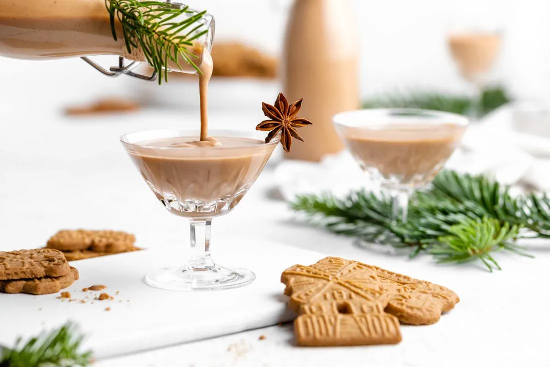 Der cremige Spekulatius Likör mit Wodka und Amaretto wird gerade in ein Likörglas gegossen.