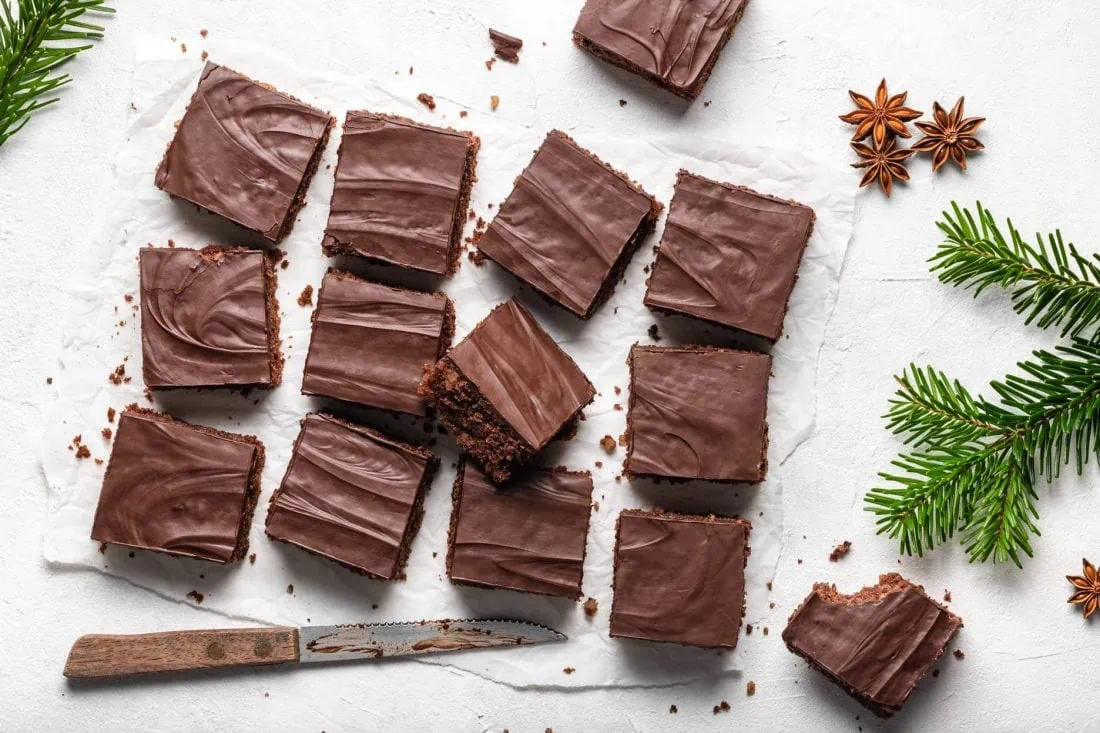 Schoko-Lebkuchen Schnitten vom Blech in gleichgroße Stücke geschnitten auf einem weißen Untergrund.
