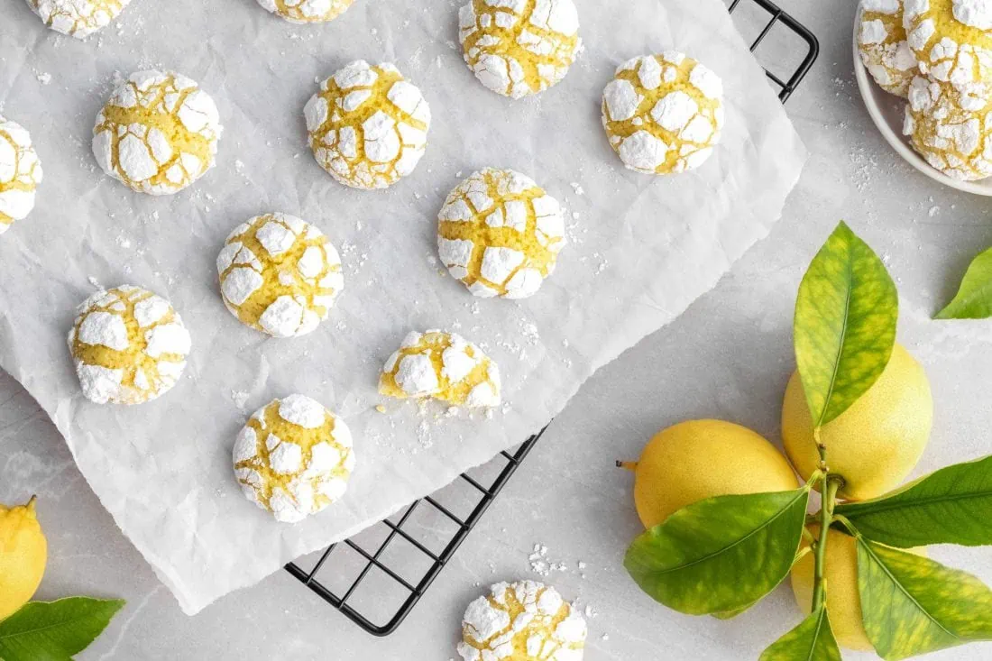 Lemon Crinkle Cookies von oben auf einem Abkühlgitter. Die Cookies sind mit einer Schicht Puderzucker überzogen.