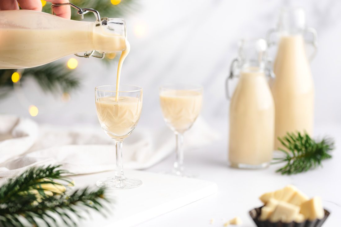 Ein selbstgemachter, cremiger Marzipanlikör mit Amaretto, Sahne und weißer Schokolade wird in ein Glas gegossen.