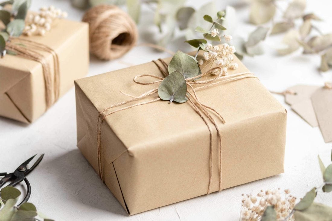Ein schönes, nachhaltig verpacktes Geschenk mit getrockneten Blumen in braunem Papier.