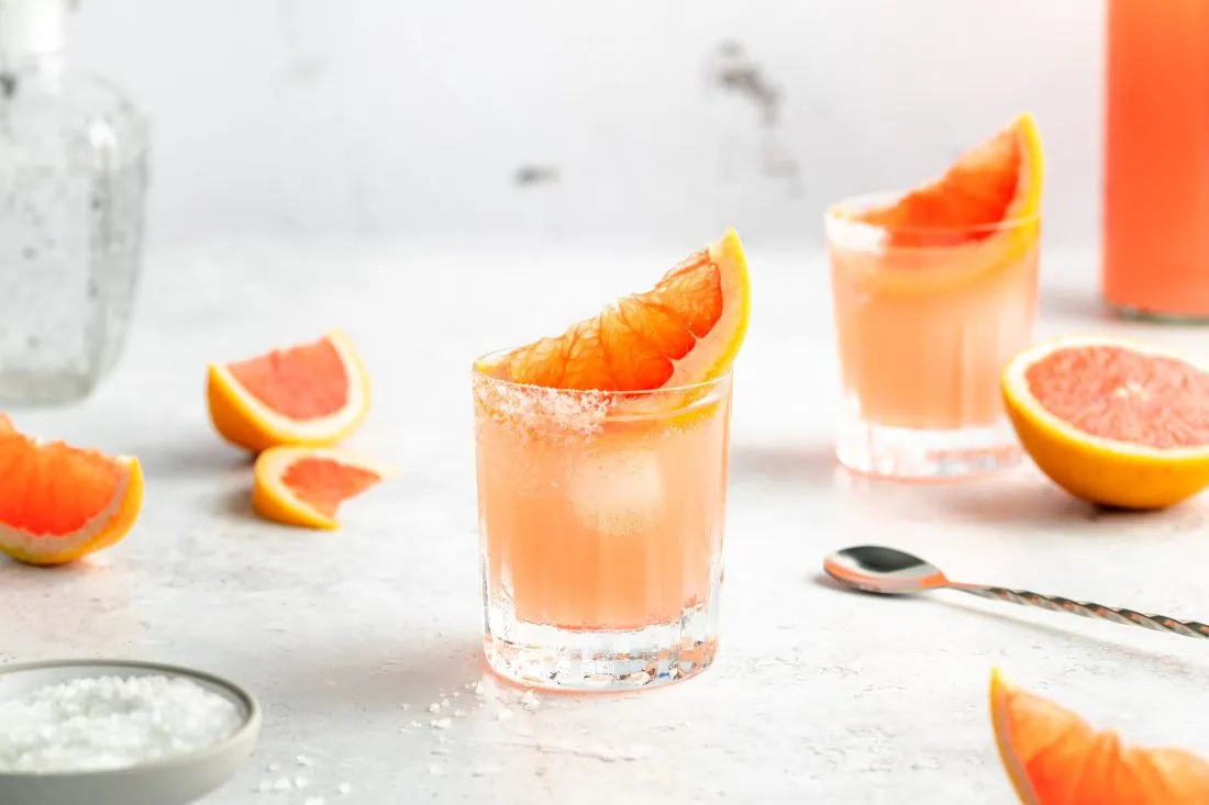 Pink-Paloma-2 Zwei Gläser Pink Paloma, ein Tequila-Cocktail, garniert mit einem Salzrand und einer Grapefruit.
