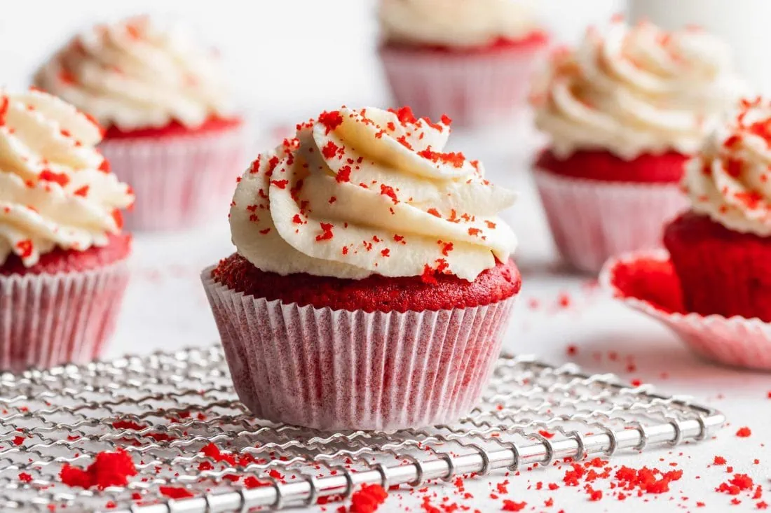 Roter Red Velvet Cupcake mit Frischkäse-Frosting auf einem hellen Untergrund.