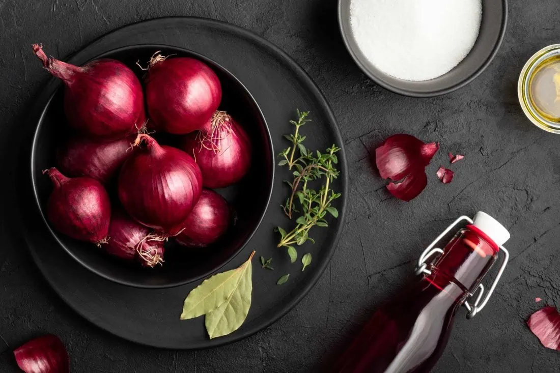 Alle Zutaten für das Rote Zwiebel Chutney im Überblick, darunter Rotweinessig, Kräuter und Zucker.