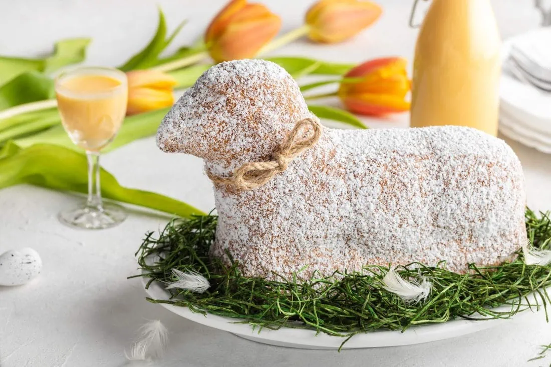 Ein saftiges Osterlamm mit Eierlikör steht auf einem Frühlingshaft dekorierten Tisch für den Osterbrunch.