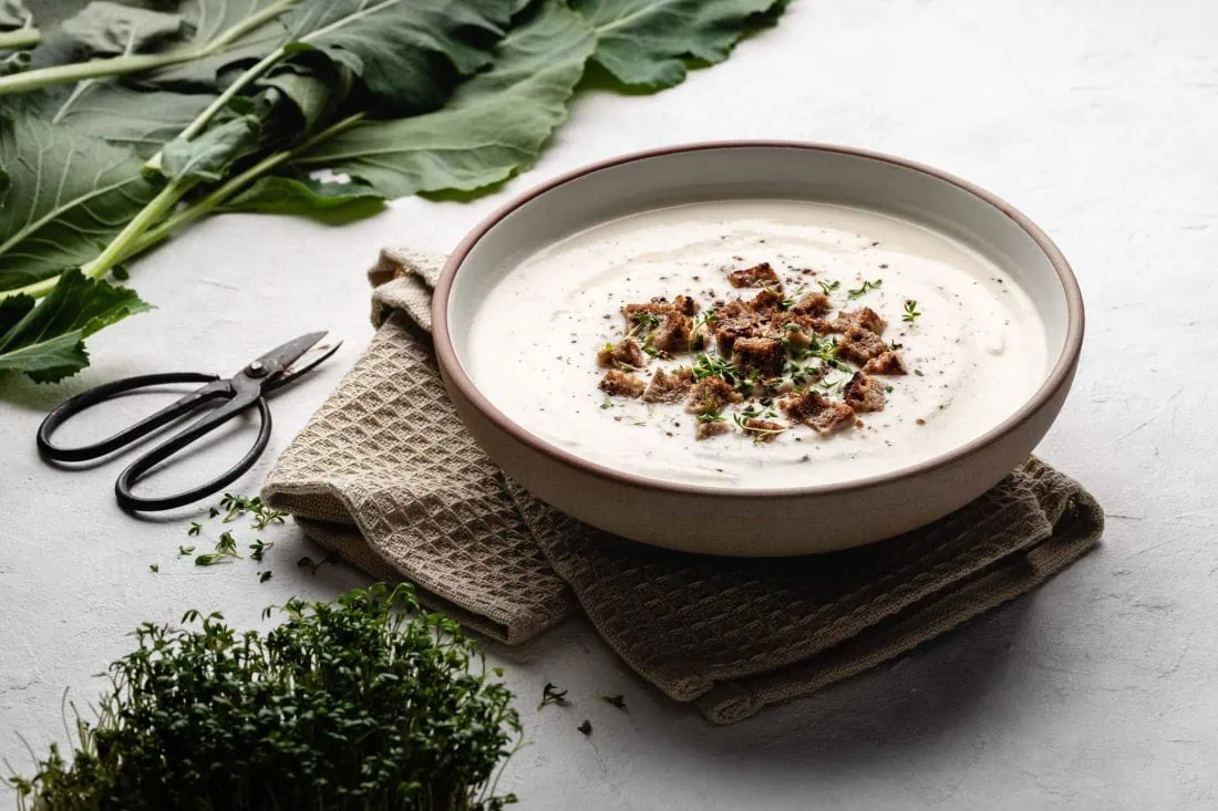 Schnelle Kohlrabisuppe mit Croûtons in einem Suppenteller garniert mit frischer Kresse.