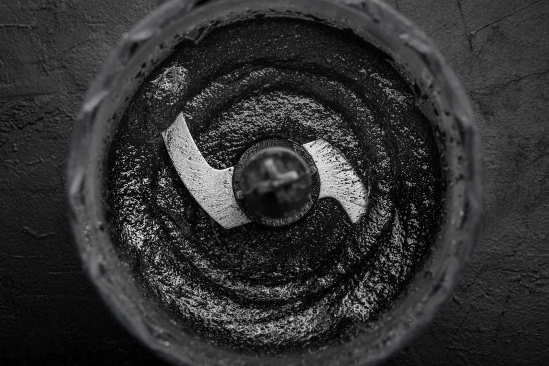 Eine schwarze,glänzende Paste in einem Food Processor aus schwarrzem Sesam, die für die Herstellung des Eises benötigt wird.