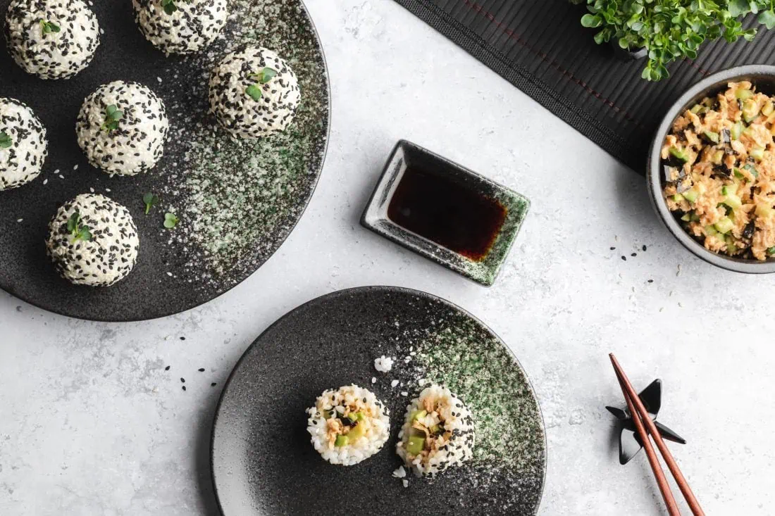 Mehrere gefüllte Sushi Balls auf einem Teller. Daneben steht die restliche Füllung.