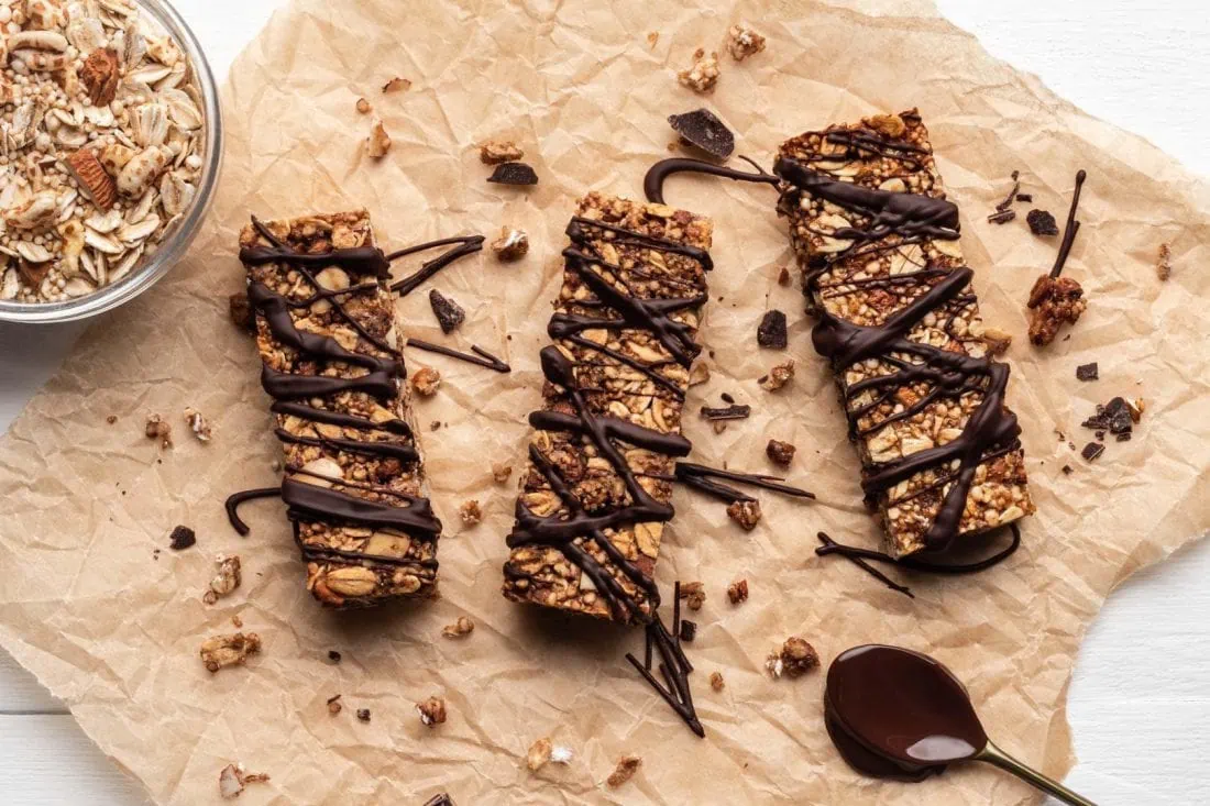 Vegane Schoko-Bananen Müsliriegel ohne raffinierten Zucker wurden gerade mit Zartbitterkuvertüre verziert.