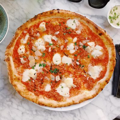 Pizza Margherita auf Tisch. Verlinkt auf Hauptgericht-Rezepte.